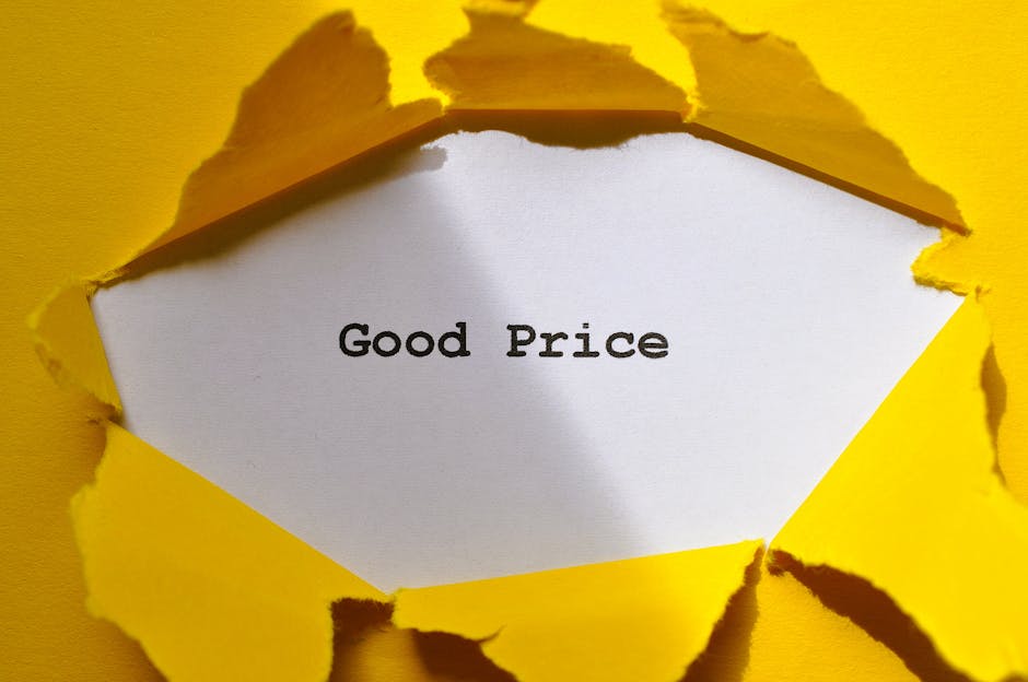 A close-up view of a yellow paper surface with a torn opening revealing a white paper underneath that displays the words 'Good Price' in black text, suggesting a message about affordable services or v